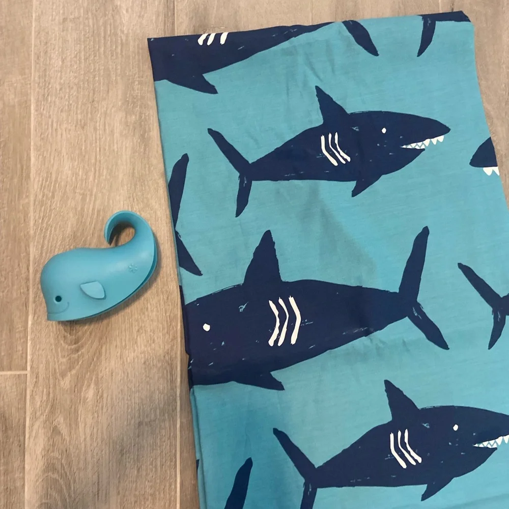 Pillowfort brand shark shower curtain and matching whale faucet cover.